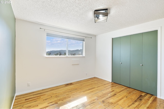 unfurnished bedroom with a closet, wood finished floors, and baseboards