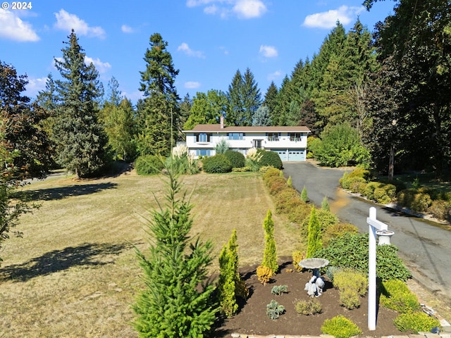 view of front facade featuring driveway, a garage, and a front lawn