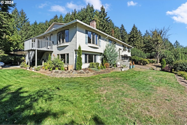 view of side of home featuring a yard, stairway, a chimney, and a wooden deck