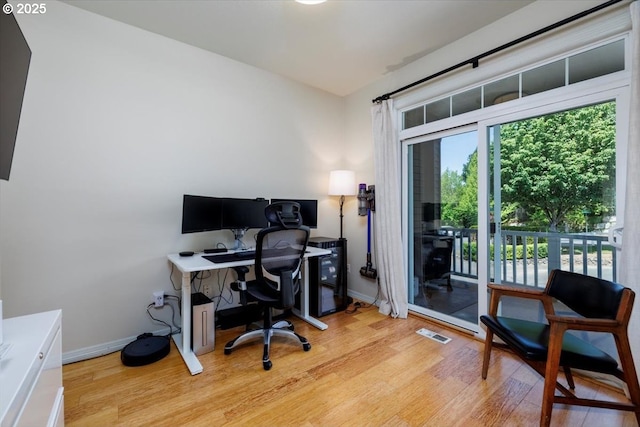 office space with light wood-type flooring and baseboards