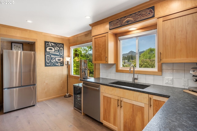 12990 I St, Nehalem, OR 97131 - kitchen featuring stainless steel appliances, a sink, decorative backsplash, light wood-style floors, and baseboards