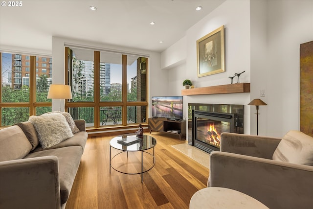 1030 NW Johnson St Unit 323, Portland, OR 97209 - living room featuring wood finished floors, a tiled fireplace, and recessed lighting
