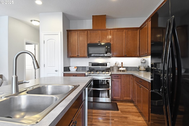 kitchen featuring sink, dark hardwood / wood-style flooring, and black appliances