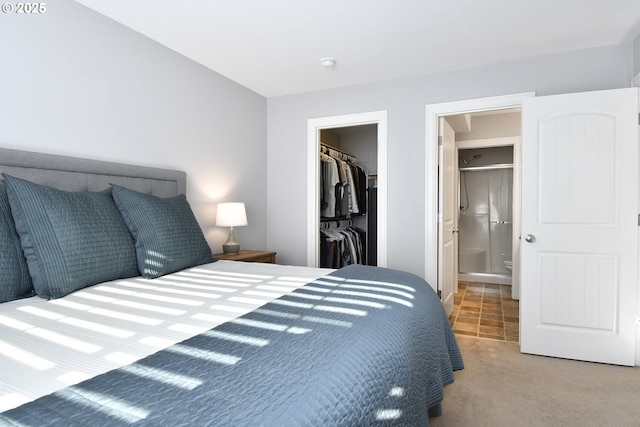 bedroom featuring a walk in closet, connected bathroom, carpet, and a closet