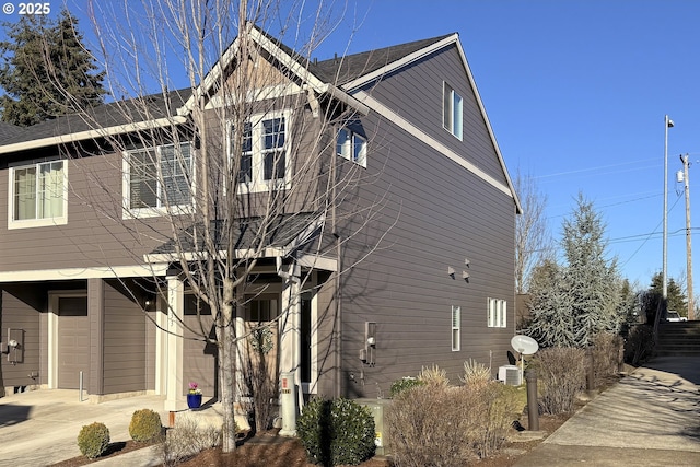 view of property exterior featuring a garage and central AC