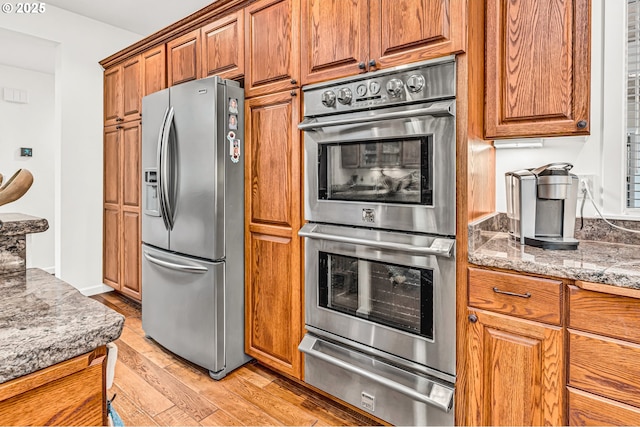 780 Pinecrest Dr, Grants Pass, OR 97526 - kitchen with appliances with stainless steel finishes, brown cabinets, light wood-type flooring, and a warming drawer