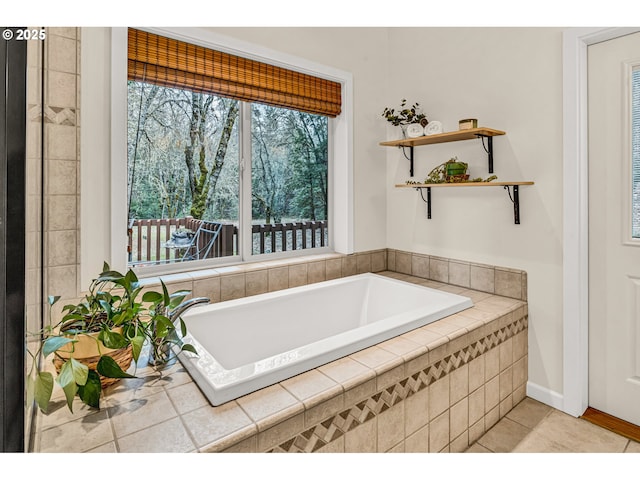 bathroom featuring baseboards, tile patterned flooring, and a garden tub