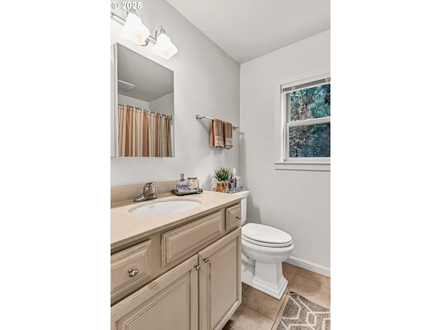 bathroom with vanity, tile patterned flooring, baseboards, and toilet