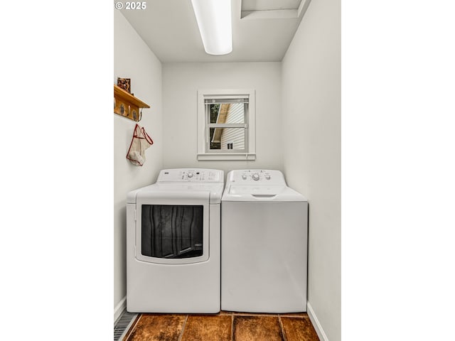 clothes washing area featuring laundry area, baseboards, and separate washer and dryer