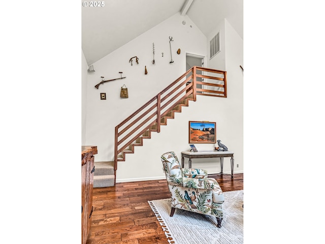 stairs with beam ceiling, high vaulted ceiling, baseboards, wood finished floors, and visible vents