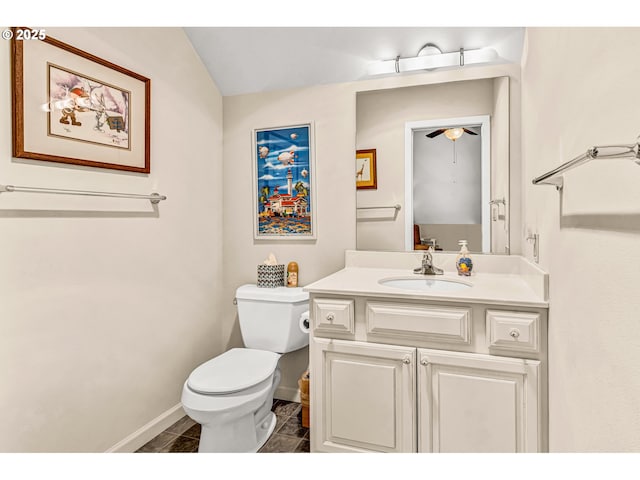 bathroom featuring toilet, baseboards, a ceiling fan, and vanity