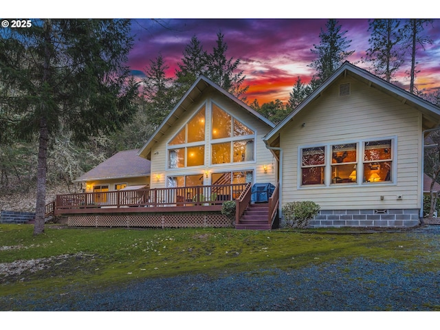 rear view of house with a lawn and a wooden deck