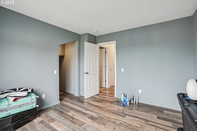 bedroom with baseboards and wood finished floors