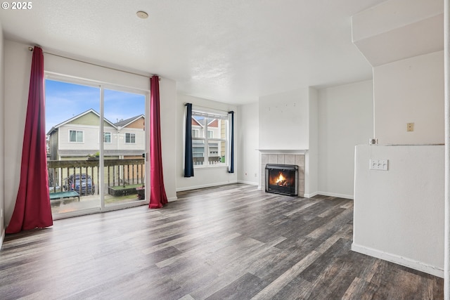 unfurnished living room featuring baseboards, wood finished floors, and a fireplace