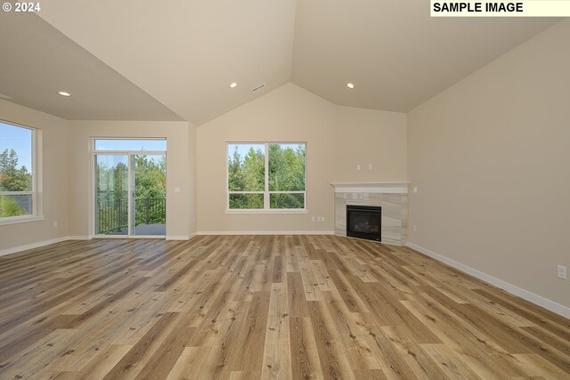17367 SW Atfalati Ln Unit 42, Sherwood, OR 97140 - unfurnished living room featuring light wood-style floors, lofted ceiling, and baseboards