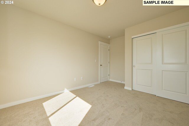 17367 SW Atfalati Ln Unit 42, Sherwood, OR 97140 - unfurnished bedroom featuring light carpet, baseboards, and a closet