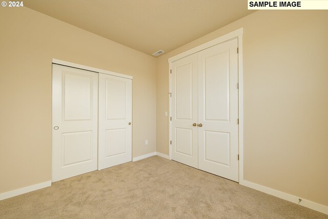 17367 SW Atfalati Ln Unit 42, Sherwood, OR 97140 - unfurnished bedroom with baseboards, visible vents, carpet floors, and a closet