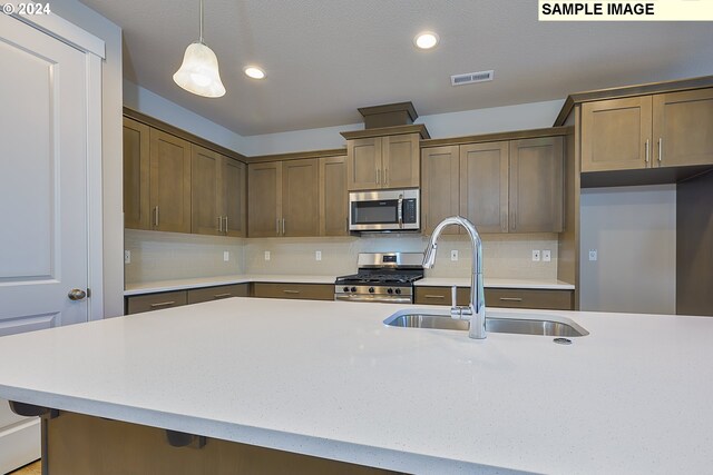 17367 SW Atfalati Ln Unit 42, Sherwood, OR 97140 - kitchen featuring stainless steel appliances, light countertops, visible vents, a sink, and decorative light fixtures