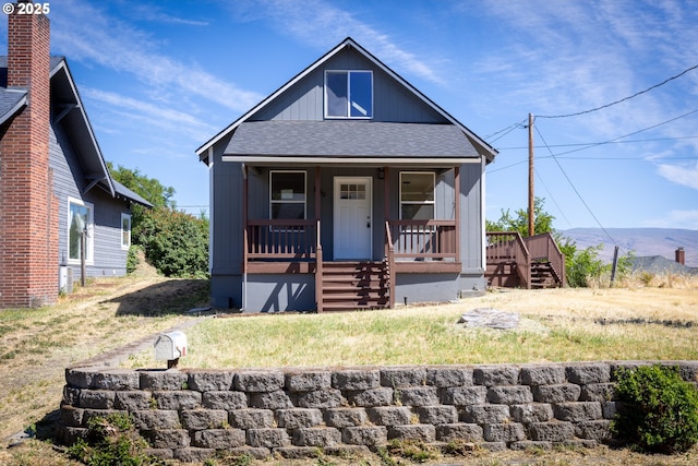 809 E 7th St, The Dalles, OR 97058 - view of front of property featuring a shingled roof, a porch, a mountain view, and stairs