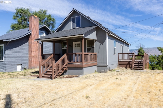 809 E 7th St, The Dalles, OR 97058 - view of front facade featuring a porch, a shingled roof, a chimney, and stairs