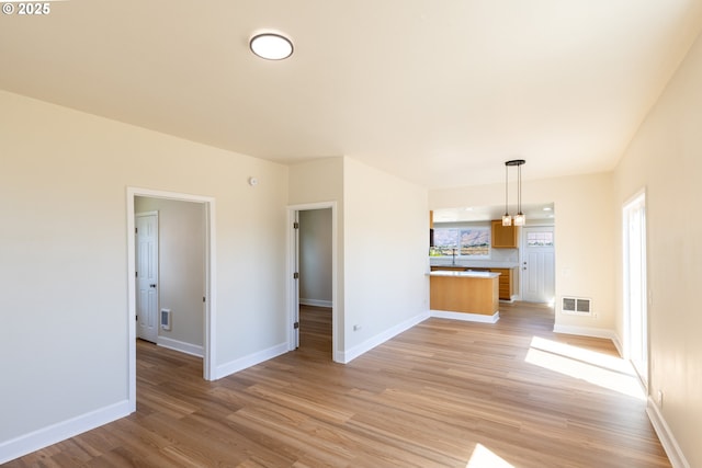809 E 7th St, The Dalles, OR 97058 - unfurnished living room with light wood-type flooring and baseboards