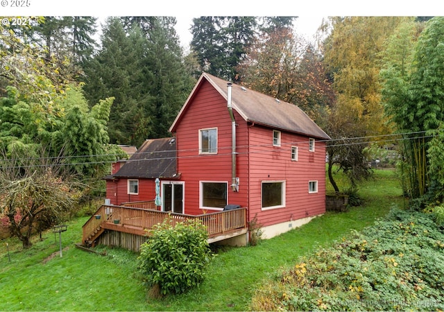 back of property with a wooden deck and a lawn