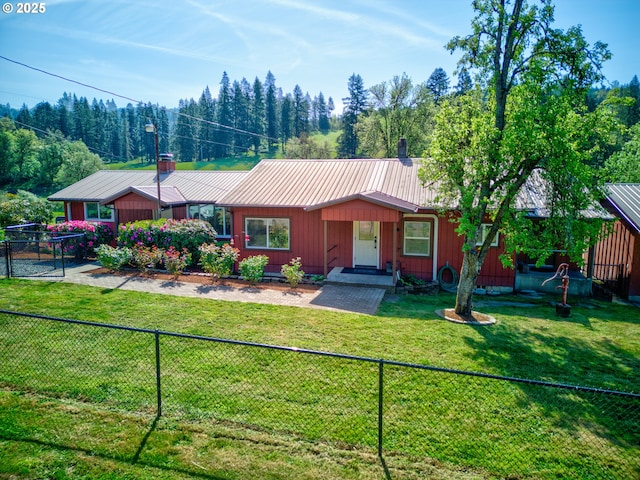 single story home featuring a fenced backyard, a front lawn, a chimney, and metal roof