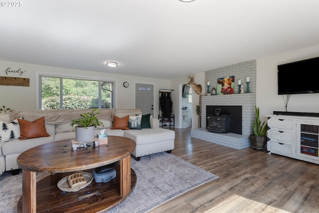 living room with a wood stove and wood finished floors