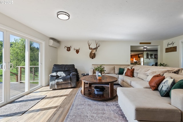 living room featuring an AC wall unit and light wood finished floors