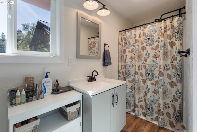 bathroom with a shower with shower curtain, wood finished floors, and vanity