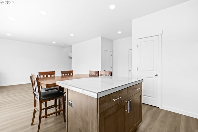 2095 S Heather St, Cornelius, OR 97113 - kitchen with light wood-style floors, recessed lighting, a kitchen island, a kitchen bar, and light countertops
