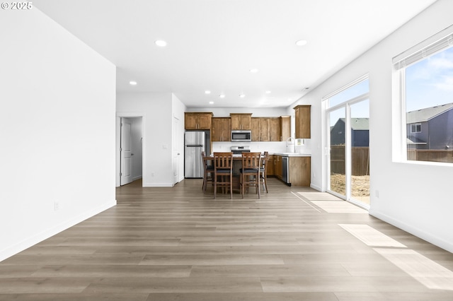 2095 S Heather St, Cornelius, OR 97113 - kitchen featuring appliances with stainless steel finishes, brown cabinetry, recessed lighting, open floor plan, and a kitchen island