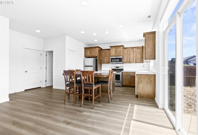 2095 S Heather St, Cornelius, OR 97113 - kitchen with appliances with stainless steel finishes, a kitchen island, light countertops, light wood finished floors, and recessed lighting