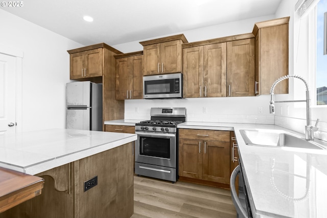 2095 S Heather St, Cornelius, OR 97113 - kitchen featuring appliances with stainless steel finishes, light wood finished floors, brown cabinetry, light countertops, and recessed lighting