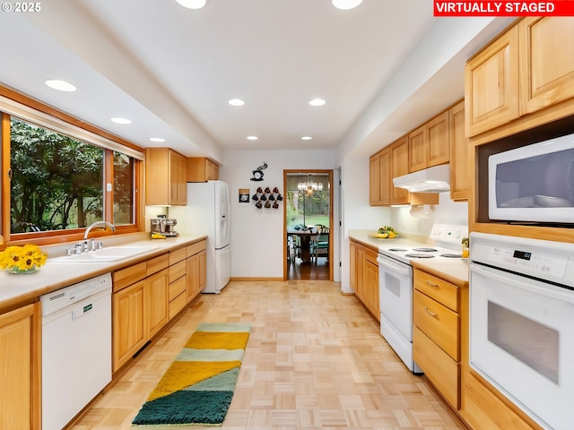 kitchen featuring light countertops, white appliances, recessed lighting, under cabinet range hood, and a sink