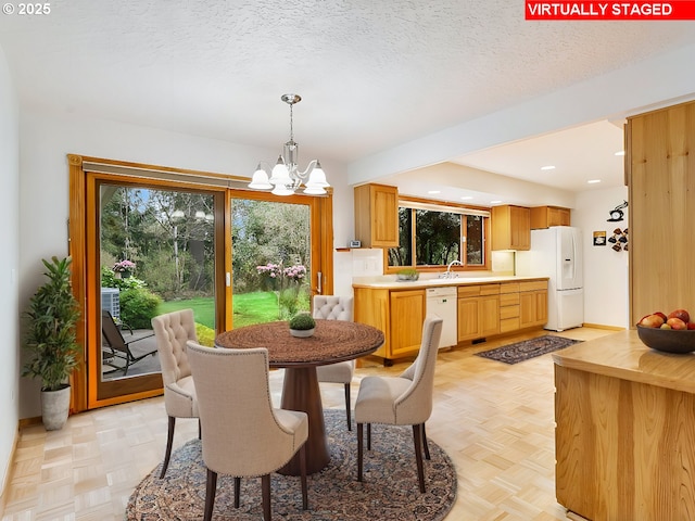 dining room with recessed lighting, a notable chandelier, baseboards, and a textured ceiling