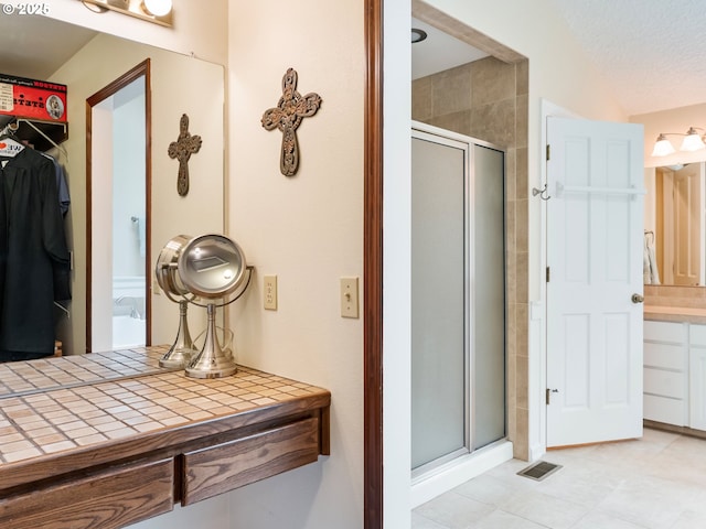 full bathroom with a stall shower, visible vents, and a walk in closet