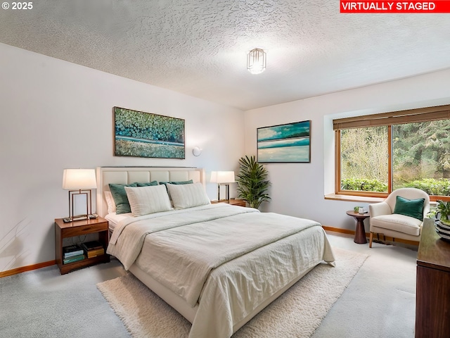 carpeted bedroom featuring baseboards and a textured ceiling