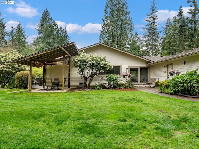 back of house with a lawn and a patio