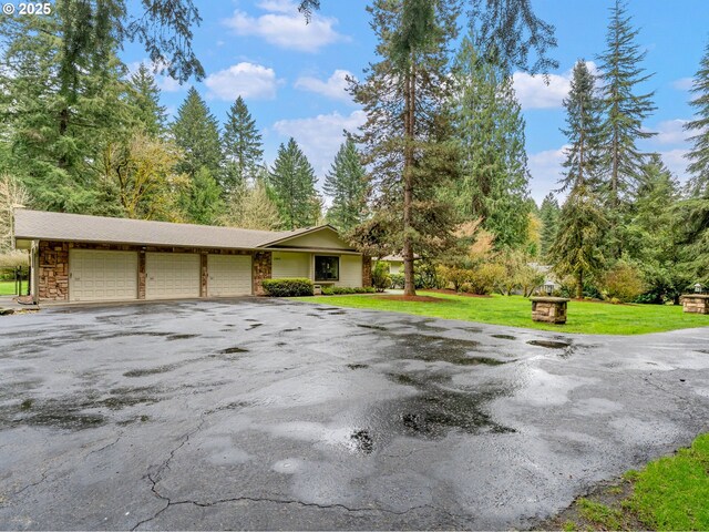 view of front of house featuring driveway, a front lawn, and an attached garage