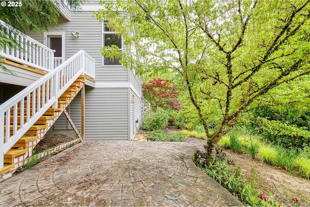 view of side of home with a patio and stairway