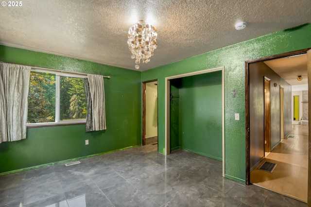 14173 NW Grandview Pl, Banks, OR 97106 - unfurnished bedroom featuring a textured ceiling, a chandelier, and a textured wall