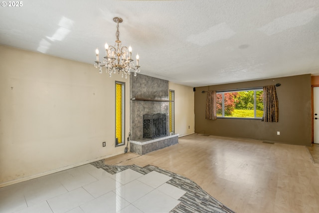 14173 NW Grandview Pl, Banks, OR 97106 - unfurnished living room with a textured ceiling, a tile fireplace, a chandelier, and baseboards