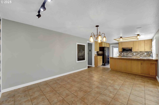 1168 Risden Pl, Eugene, OR 97404 - kitchen with stainless steel microwave, freestanding refrigerator, light tile patterned floors, a peninsula, and a chandelier