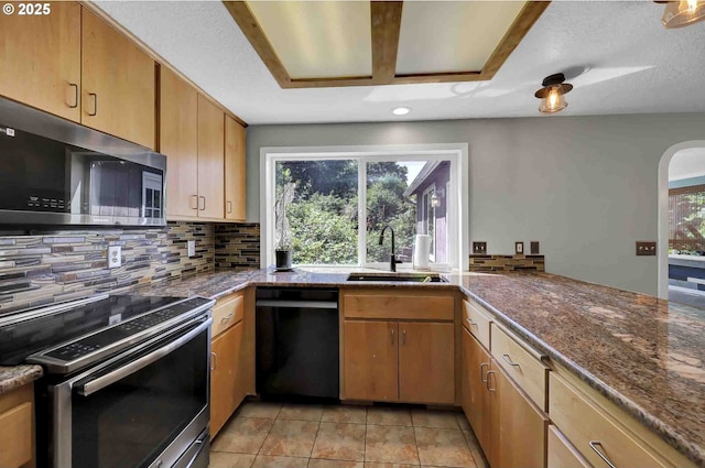 1168 Risden Pl, Eugene, OR 97404 - kitchen featuring appliances with stainless steel finishes, decorative backsplash, light tile patterned flooring, recessed lighting, and dark stone countertops