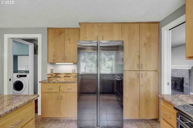 1168 Risden Pl, Eugene, OR 97404 - kitchen with freestanding refrigerator, washer / dryer, light stone counters, a textured ceiling, and light tile patterned flooring