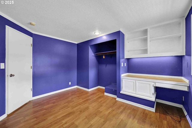 1168 Risden Pl, Eugene, OR 97404 - unfurnished bedroom with a textured ceiling, built in desk, wood finished floors, and a closet