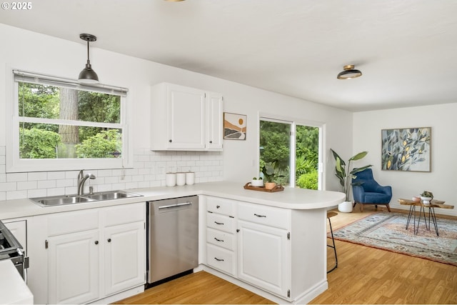 1070 SW Portola Ave, Portland, OR 97225 - kitchen with stainless steel dishwasher, a peninsula, healthy amount of natural light, and light wood finished floors