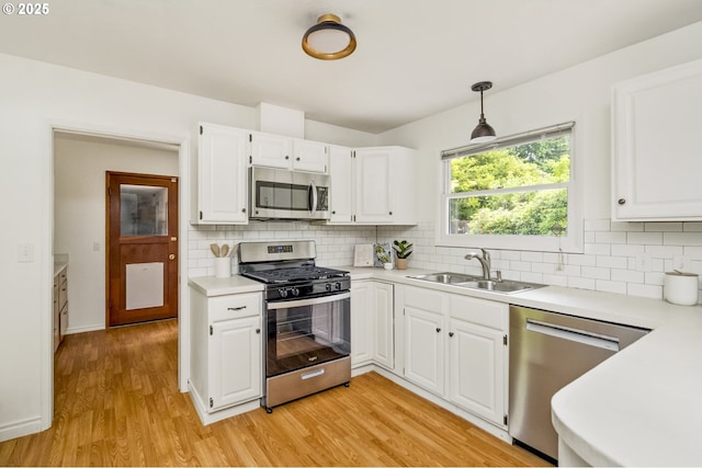 1070 SW Portola Ave, Portland, OR 97225 - kitchen with stainless steel appliances, light countertops, light wood-style flooring, and tasteful backsplash