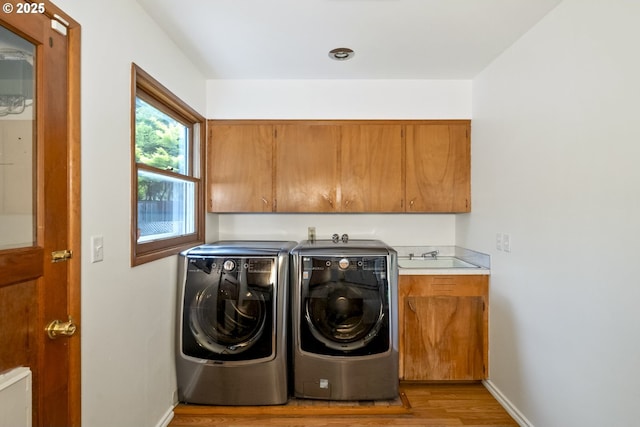 1070 SW Portola Ave, Portland, OR 97225 - washroom featuring cabinet space, washing machine and clothes dryer, and light wood-style flooring